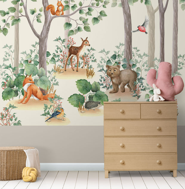 Woodland-themed wall mural featuring a bear cub, deer, squirrel, birds and lush green trees, decorating a cozy children's bedroom with a wooden house bed and natural decor.