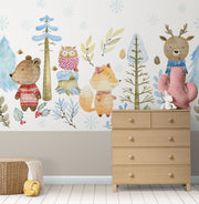 Winter woodland animal wall mural featuring a bear, fox, deer, and owl in cozy knitted sweaters, surrounded by snow-covered trees and soft blue foliage.