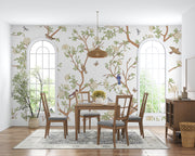 Nature-inspired floral and bird wall mural featuring blooming flowers, branches, birds, and butterflies in a living room setting.