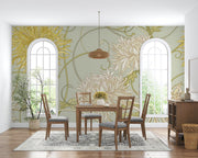Art Nouveau floral wall mural with intricate yellow and beige chrysanthemum flowers on a sage-green background, styled in a cozy dining space.