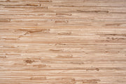 A close-up texture of a woven natural fiber mat, showing horizontal strands in shades of light brown and beige.