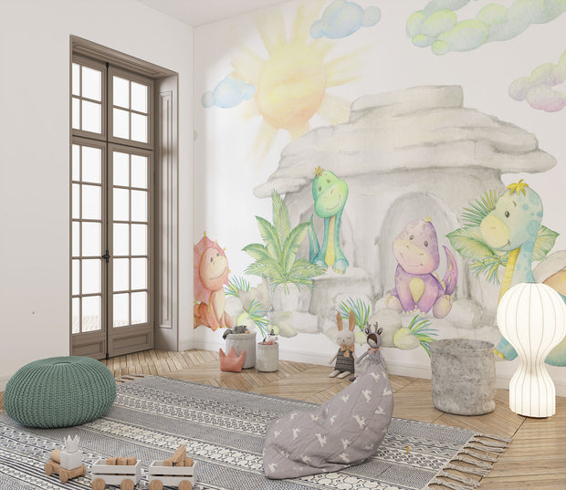 Pastel dinosaur wall mural with soft watercolor-style dinosaurs, a cozy stone cave, lush greenery, and a glowing sun, perfect for nurseries and playrooms.