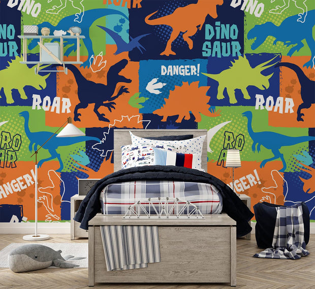 Colorful dinosaur themed wall mural featuring vibrant dinosaur silhouettes, footprints and phrases like "ROAR" and "DANGER," decorating a kid's bedroom with cozy furniture.