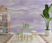 Purple wave-pattern wall mural featuring soft, flowing designs, decorating a kid's playroom with a small table, pastel-coloured chairs, toys and a large potted plant.