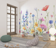 Watercolor wildflower wall mural featuring hand-painted flowers in vibrant colors with butterflies, styled in a playful children’s room with a white teepee.