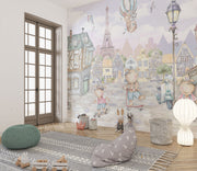 A whimsical Paris-inspired nursery wall mural featuring teddy bears on scooters and bikes, cobblestone streets, and the Eiffel Tower in pastel tones.