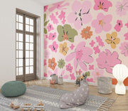 Vibrant floral wall mural featuring pink, orange and green abstract flowers, decorating a children’s playroom.