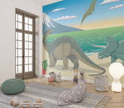 Dinosaur wall mural featuring a scenic beach with a Brachiosaurus, Triceratops, ocean waves, and a soaring Pteranodon at sunset.