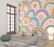Kids wall mural with retro-style rainbow arches and colorful flowers in a playful, children's playroom.