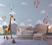 Scandinavian-style mountain nursery wallpaper with floating hot air balloons decorating nursery.
