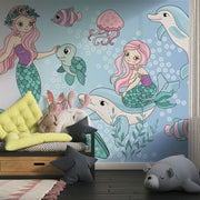 Whimsical underwater-themed mural with pastel mermaids, dolphins, turtles, jellyfish, and fish set against a blue bubble-filled background in a cozy kids' room.