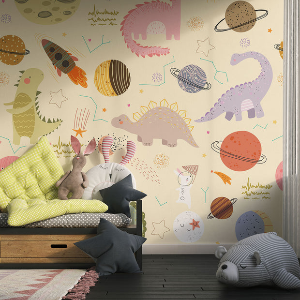Children's playroom with Dino Galaxy Wall Mural featuring whimsical dinosaurs, rockets, planets, and stars in pastel colors, creating a magical space-themed decor.
