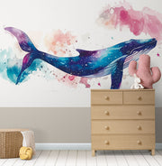 Vibrant galaxy whale wall mural featuring a watercolor-style blue whale swimming through a cosmic, star-filled background in shades of blue, purple, and pink – perfect for kids' rooms and modern decor.