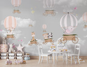 Whimsical hot air balloon animal wall mural featuring giraffes, pandas, elephants, and bears floating in the sky with soft pastel clouds – perfect for kid's rooms and nurseries.