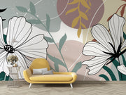 Yellow sofa in front of a wall with large floral and leaf designs.